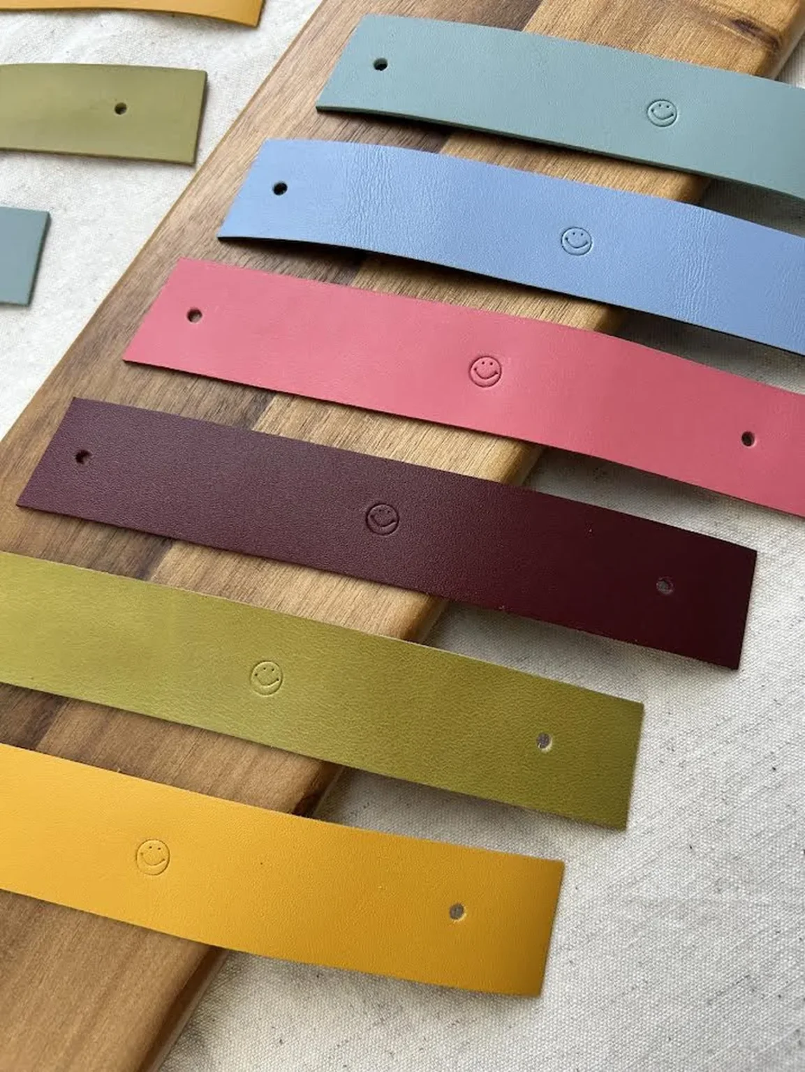 Tiras de couro coloridas para argolas de guardanapo com estampagem smile.