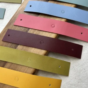 Tiras de couro coloridas para argolas de guardanapo com estampagem smile.