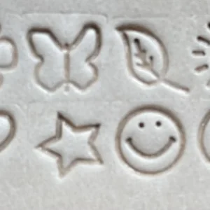 Conjunto de símbolos em couro com relevo — flor, borboleta, folha, sol, coração, estrela, smile e lua